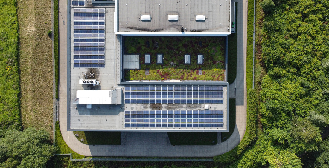 Building roof with solar panels and green spaces