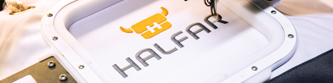 Halfar logo made in embroidery The Halfar logo is embroidered on a bag by an embroidery machine