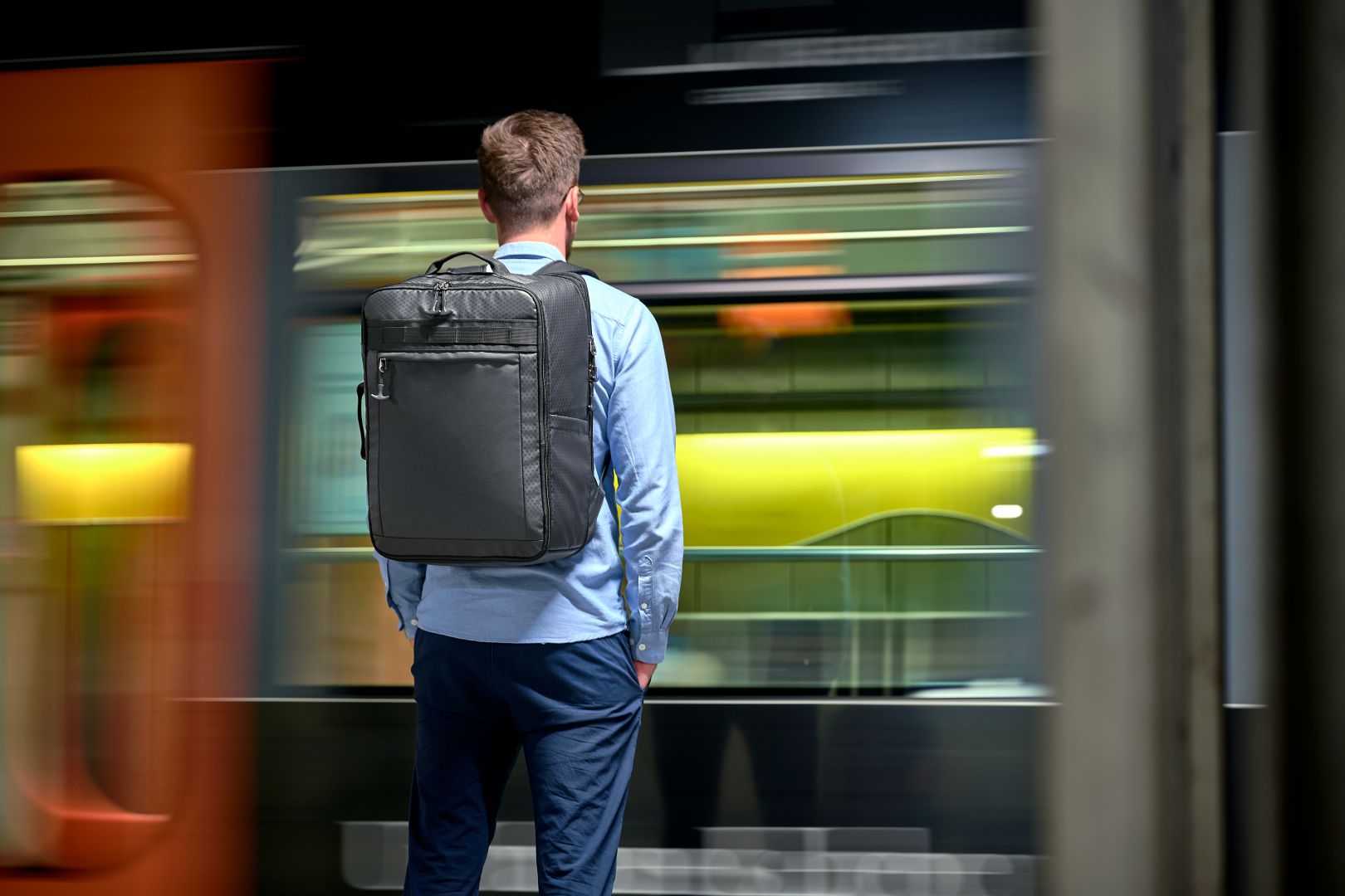 Travel rucksack ACTIVE dark green presented from behind in the underground