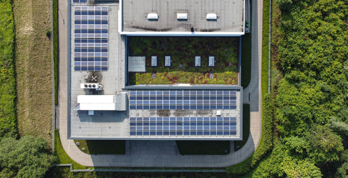 The roof of the company building with solar panels and green areas